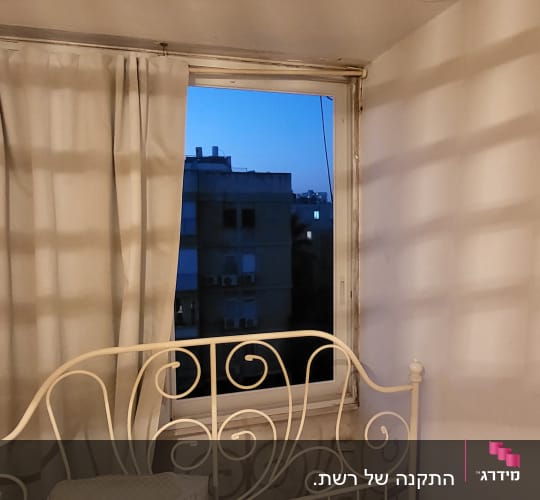 חלון אלומיניום עם מסגרת מתכת בחדר שינה